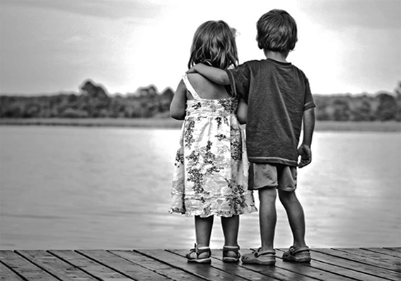 Δύο παιδιά αγκαλιασμένα κοιτούν τη θάλασσα, συμβολίζοντας τη φιλία ανάμεσα στα δύο φύλα
