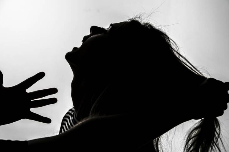 Συμβολική απεικόνιση γυναίκας σε εγκλεισμό που αναζητά βοήθεια κατά τη διάρκεια της πανδημίας.