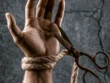 Ανοιχτή παλάμη με σκοινί στον καρπό και ψαλίδι που κόβει τον δεσμό, συμβολίζοντας την αχαριστία και τη ματαίωση της προσφοράς στις ανθρώπινες σχέσεις