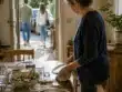 Γονέας μαζεύει το τραπέζι καθώς τα ενήλικα παιδιά φεύγουν μετά από οικογενειακό γεύμα.